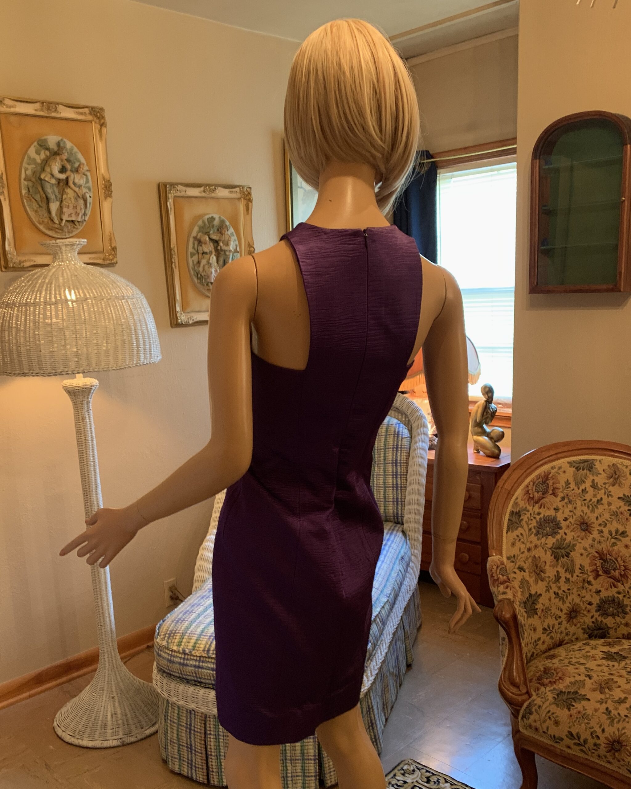 Back view of a 1980s Linda Separates violet sheath dress showing the high back neckline, back zip closure, sleeveless design, and tailored sheath silhouette.