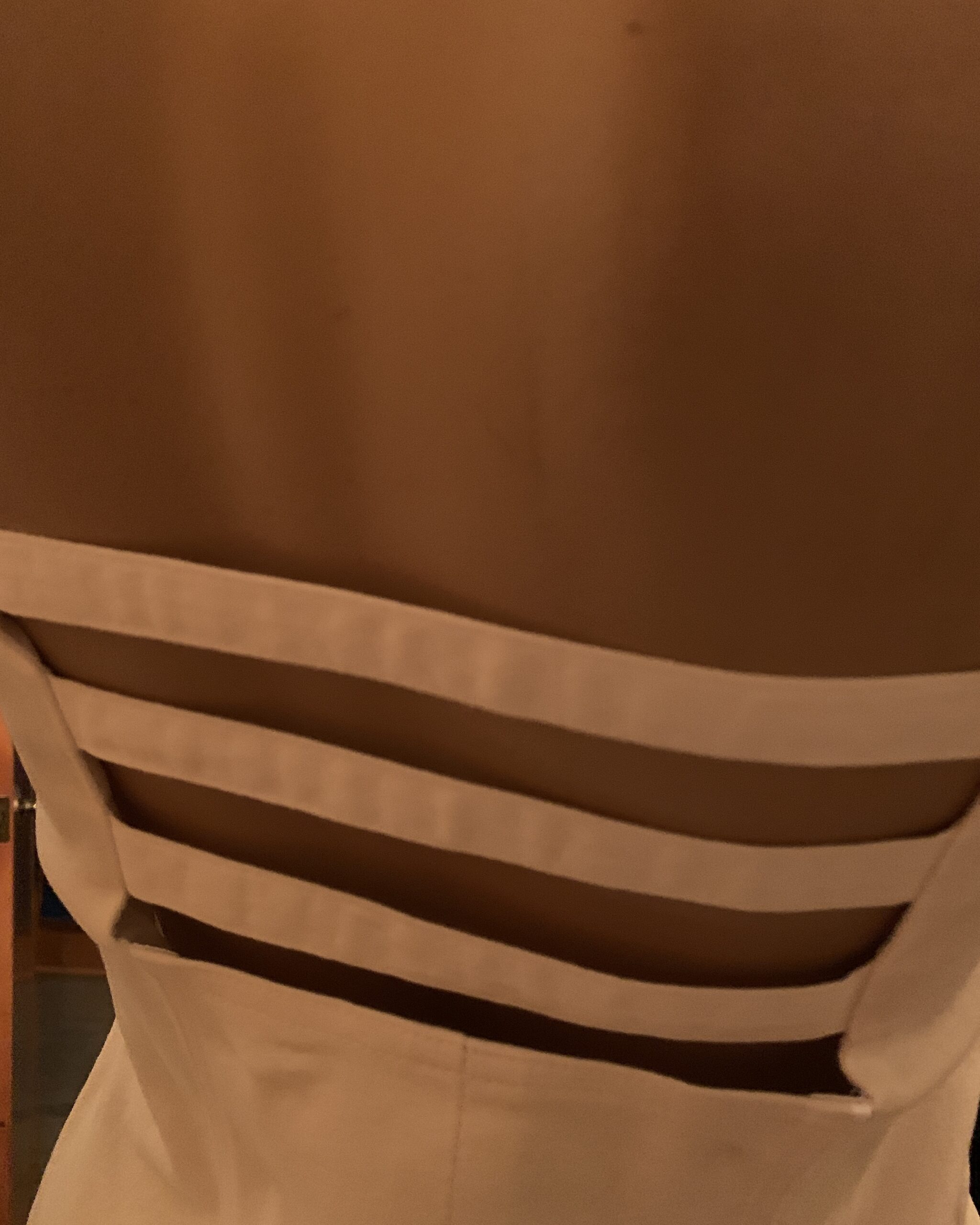Detail of the horizontal strap open-back design on a vintage Linda Segal Separates white dress.