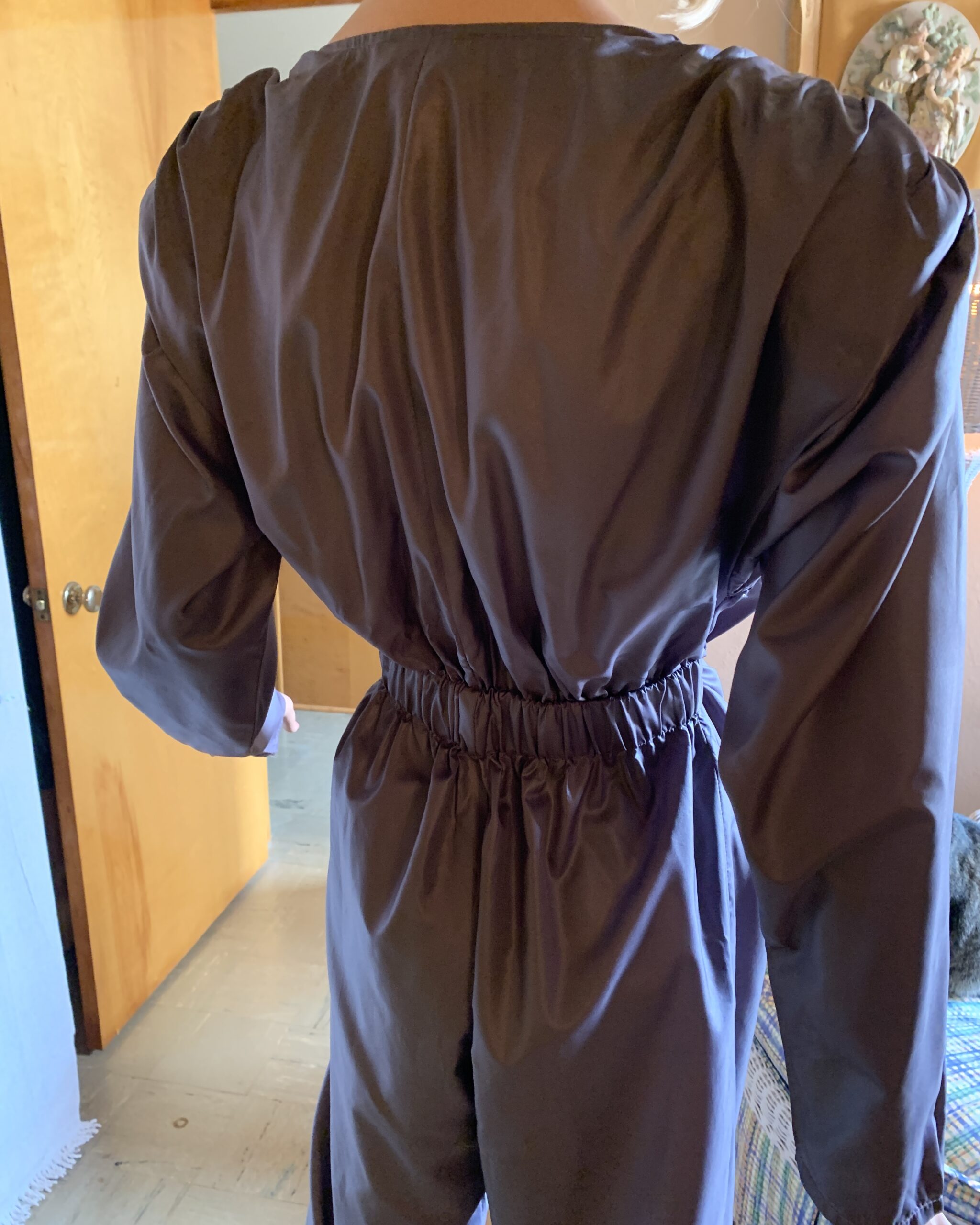 Close-up of the back waist on the Antonio Ruspoli jumpsuit highlighting the elasticized fit and smooth polyester fabric.