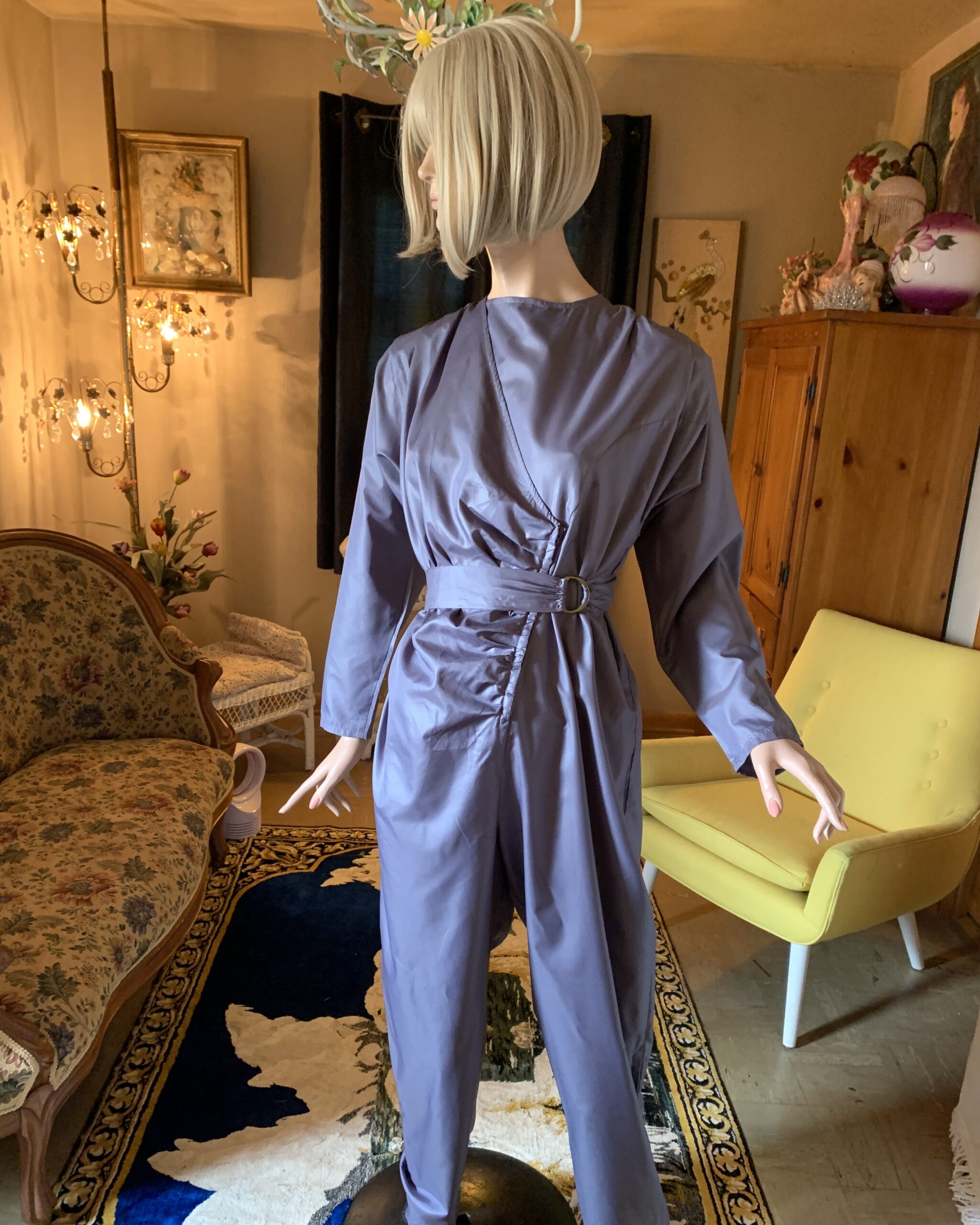 Vintage Antonio Ruspoli slate lavender jumpsuit featuring front ruching, attached D-ring belt, long sleeves, and structured shoulder pads on mannequin.