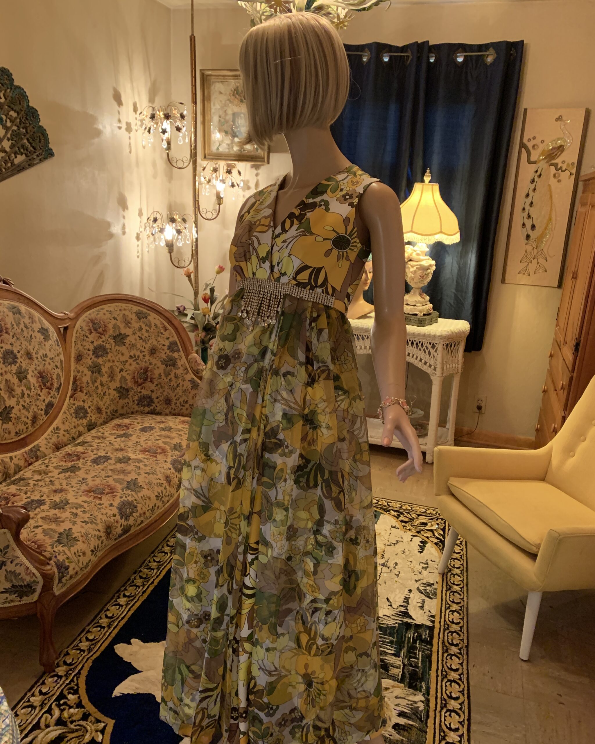Side view of vintage Carrie Couture floral jumpsuit highlighting layered chiffon overlay and rhinestone waist detail.
