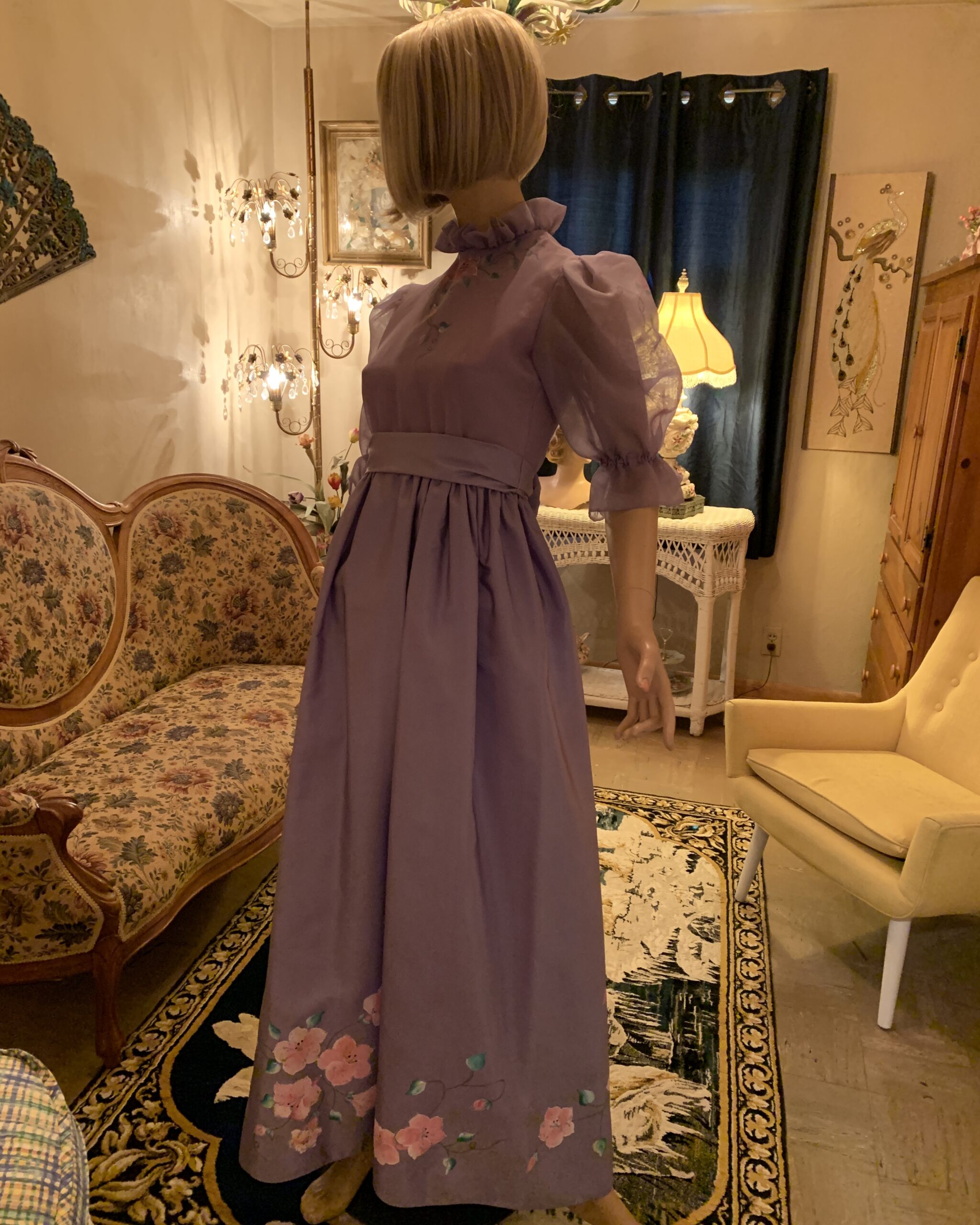 Vintage Elizabeth Arden lavender maxi dress with puff sleeves, ruffled neckline, empire waist, and hand-painted floral hem displayed on a mannequin.