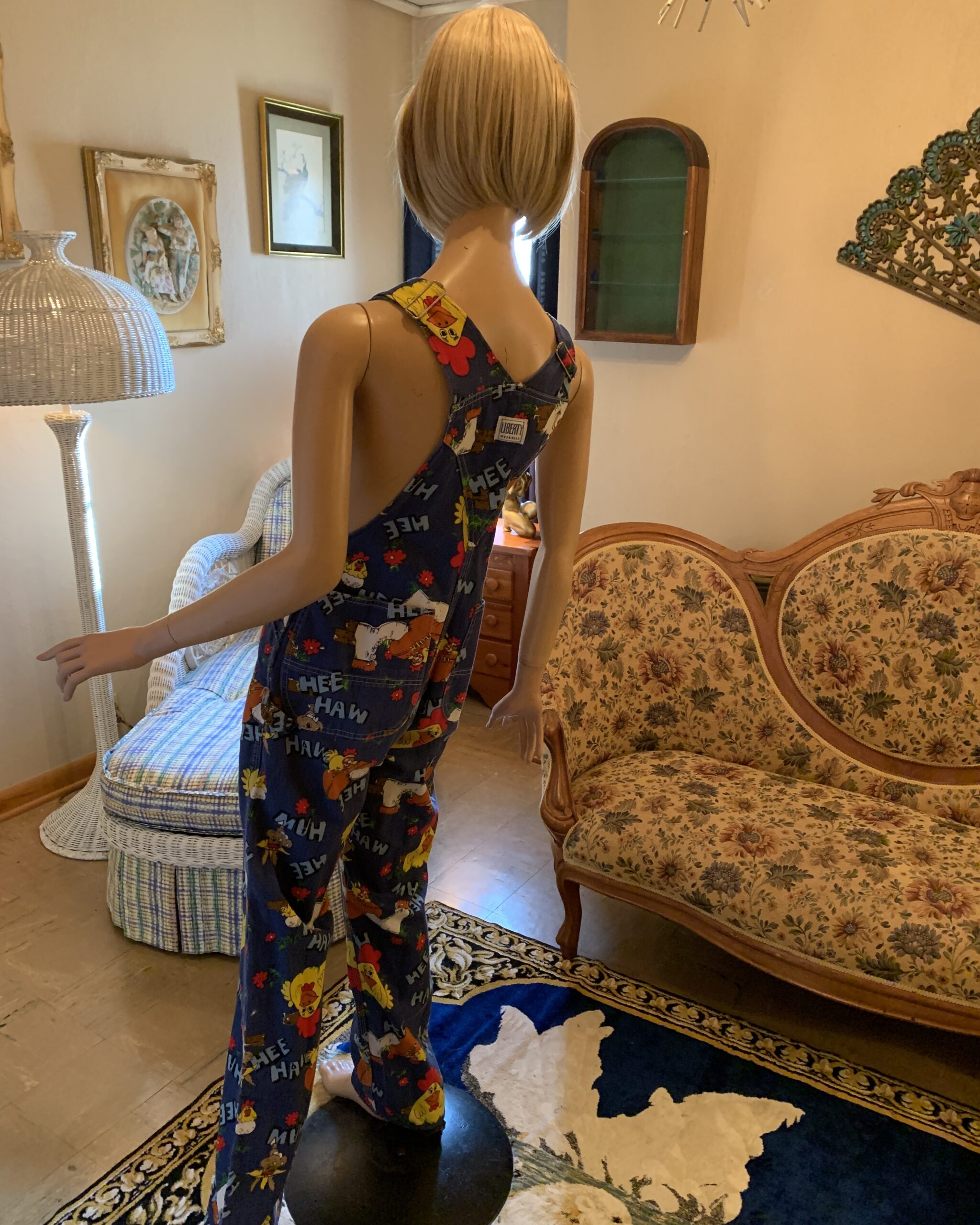 Back view of vintage Liberty Hee Haw novelty print bib overalls with crossed adjustable shoulder straps and rear patch pockets.