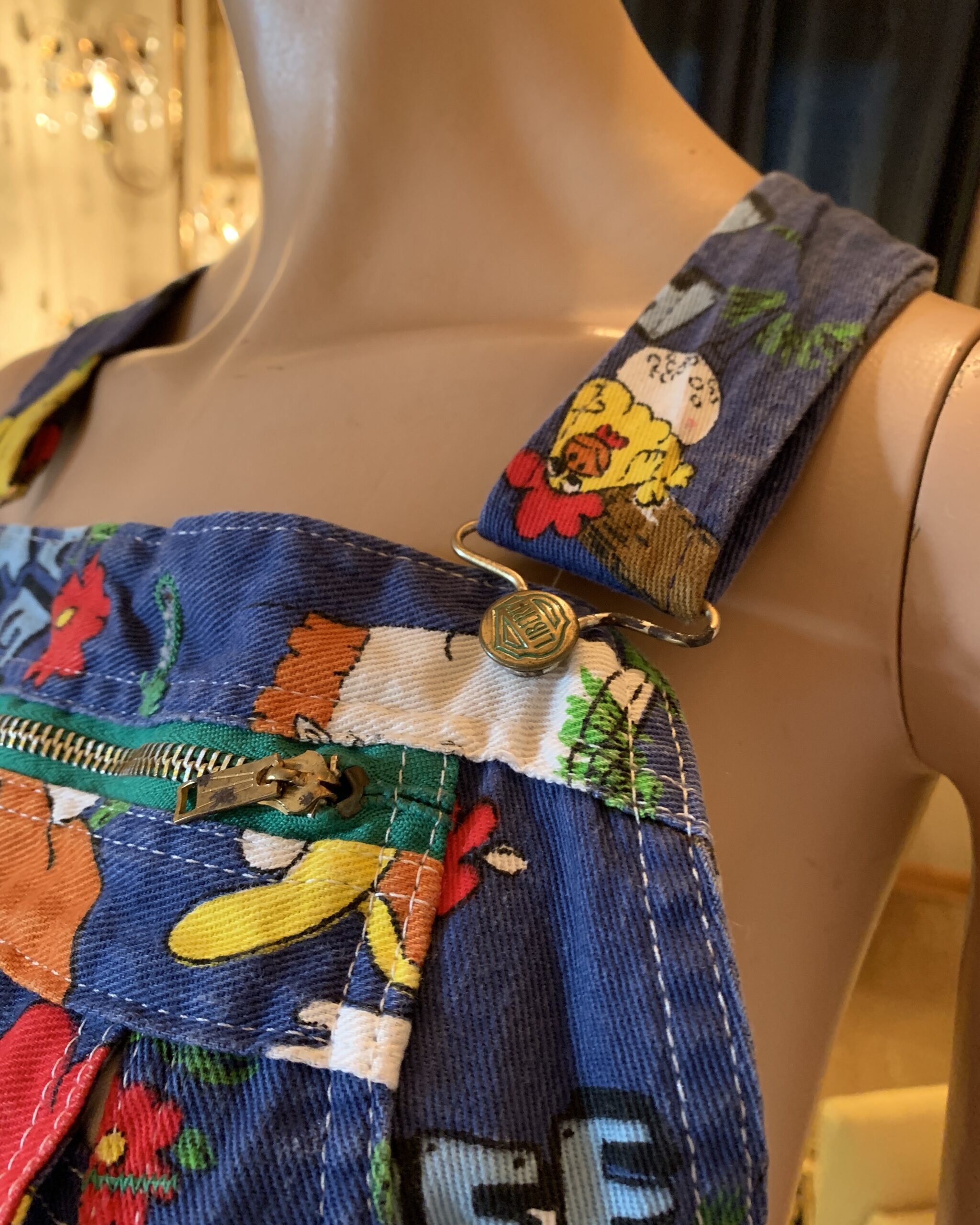 Close-up of vintage Liberty Hee Haw bib overalls showing adjustable shoulder strap and Liberty brass hardware.