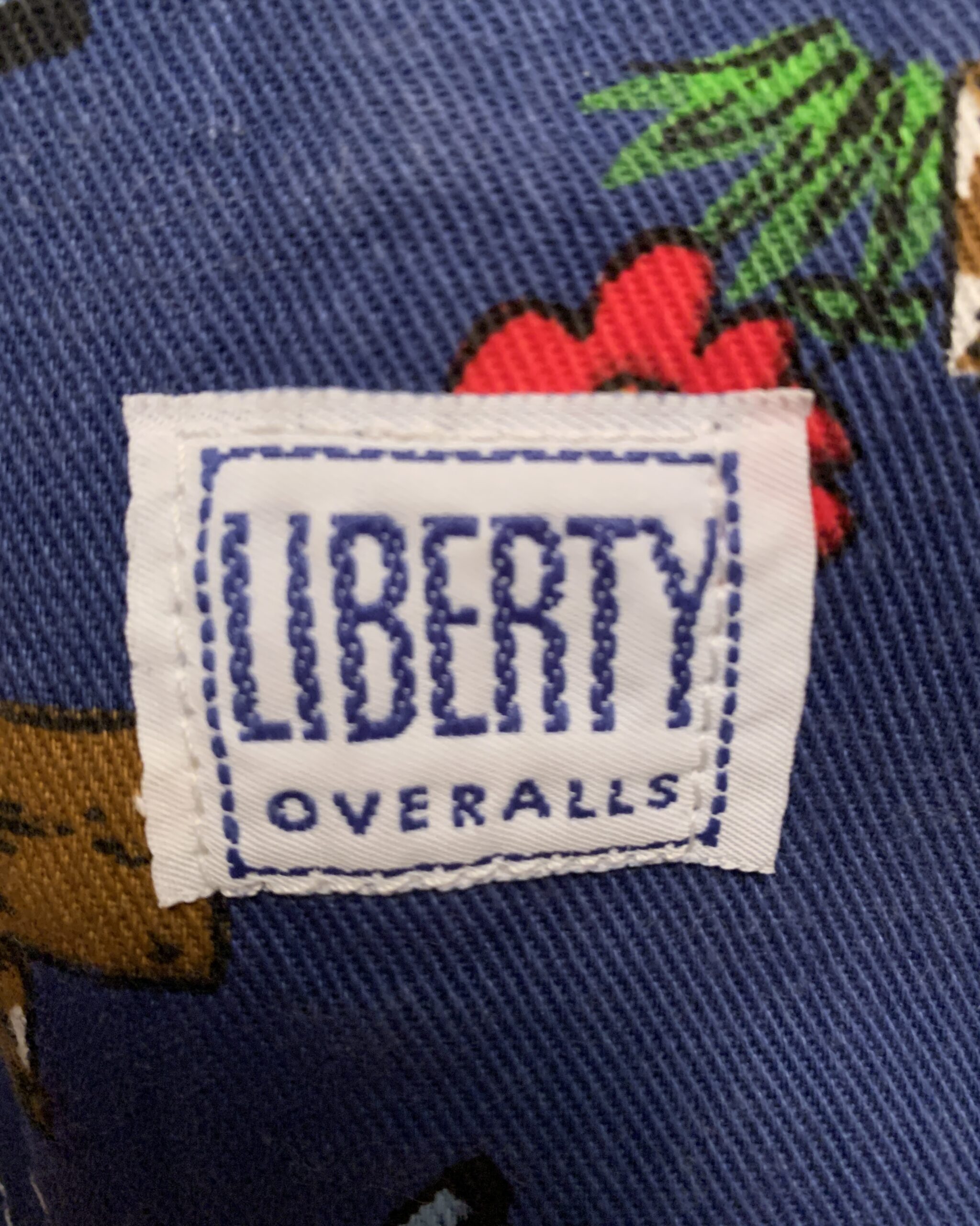 Original Liberty Overalls size tag showing Made in USA, 100% cotton, size 34x36 inside vintage Hee Haw bib overalls.
