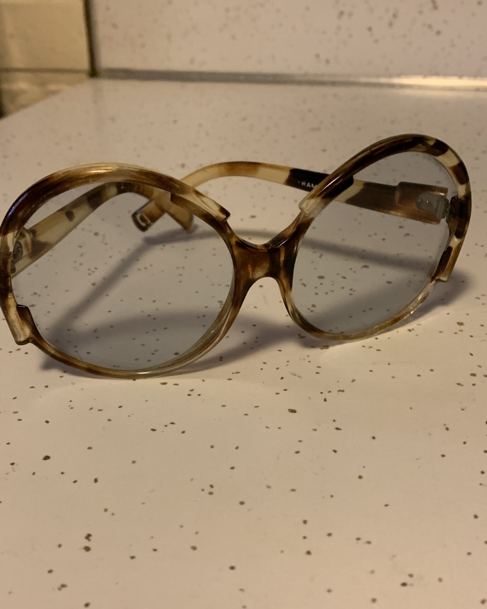 Vintage oversized tortoiseshell butterfly sunglasses with gray gradient lenses photographed on a white surface.