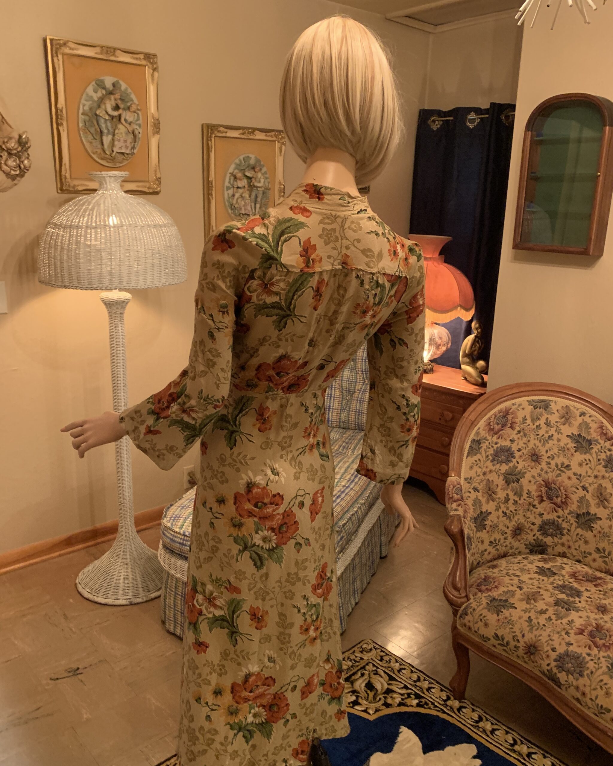 Back view of a vintage 1940s floral wrap dress with a softly gathered yoke, long sleeves, and an elegant floral print on a beige ground.