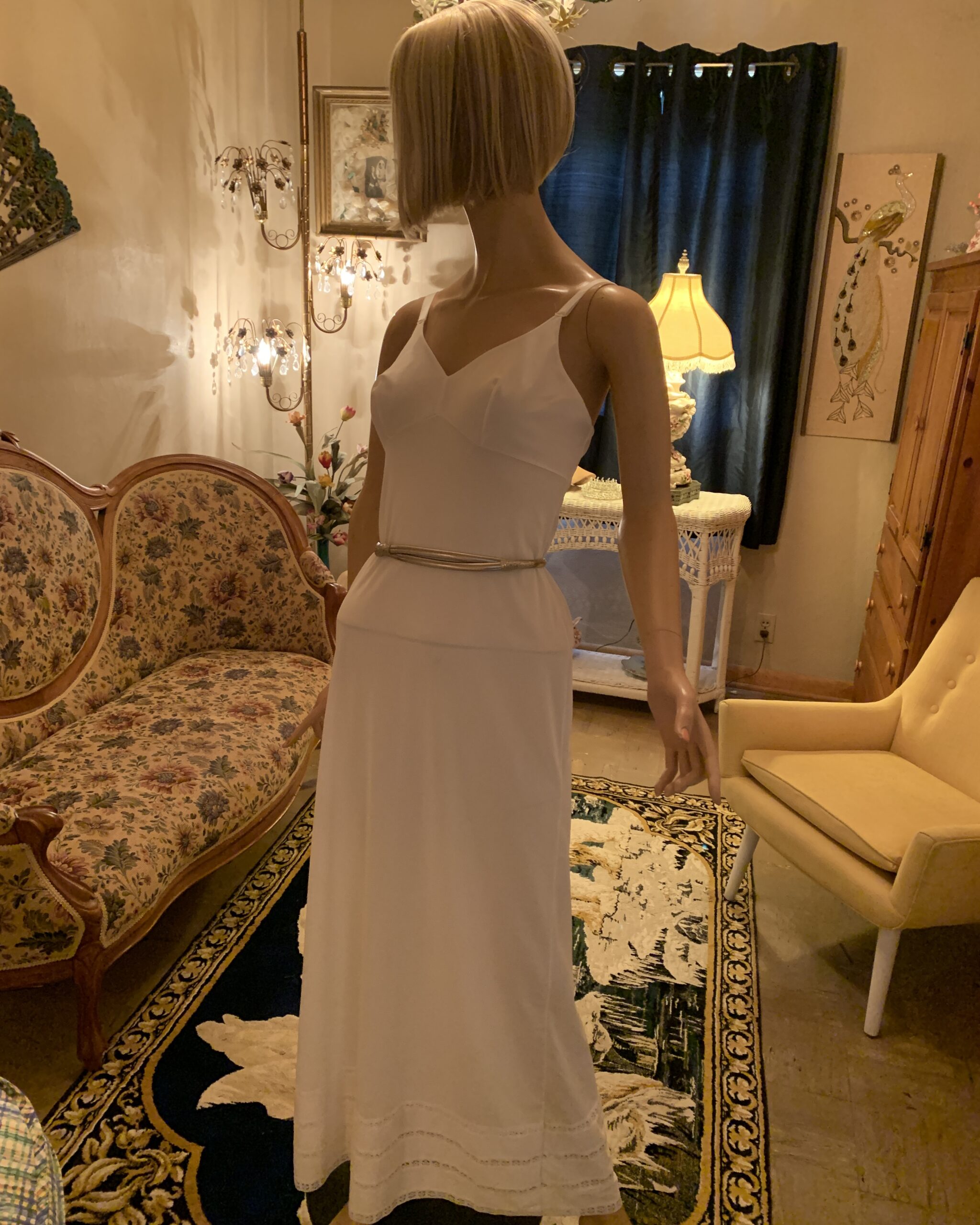 Vintage Accessocraft N.Y.C. silver-tone snake belt styled over a white slip dress on a mannequin.