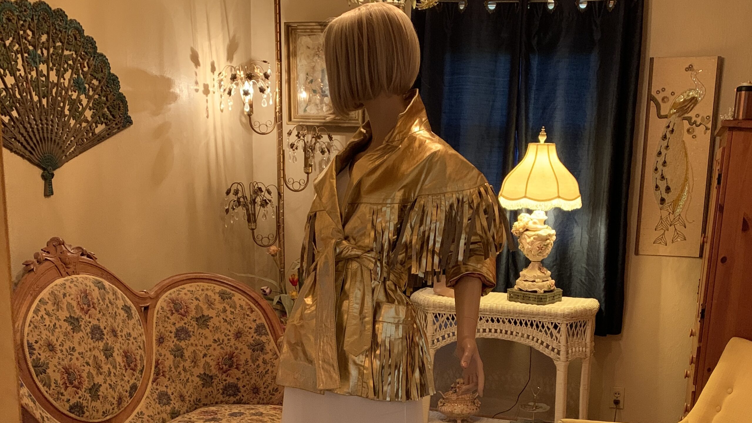 Simone mannequin wearing a metallic gold fringe jacket in a warmly lit vintage salon for The Revolving Archive Autumn Archive Collection.