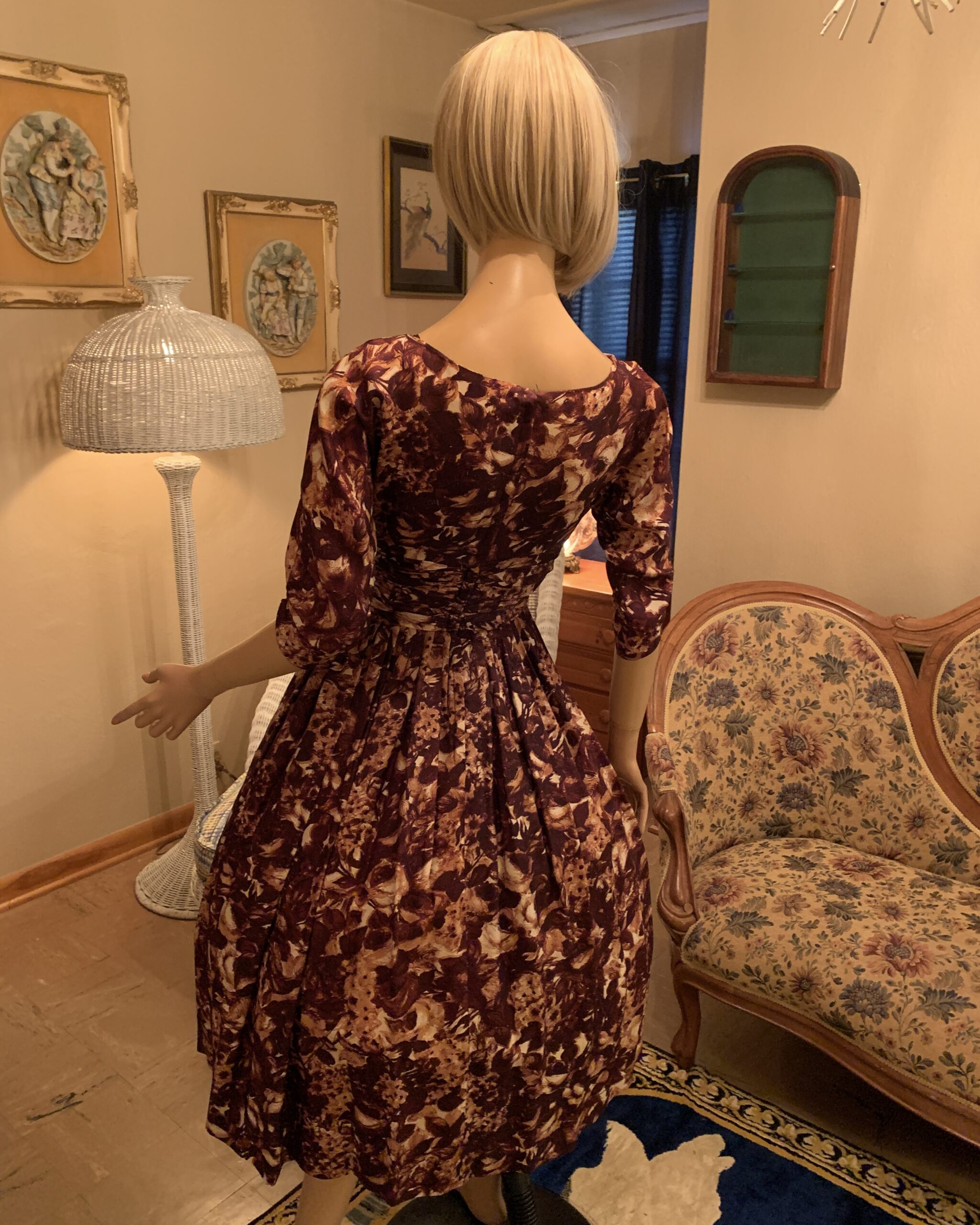 Back view of a 1950s Carol Craig New York chocolate brown abstract floral dress with a fitted waist and full gathered skirt.