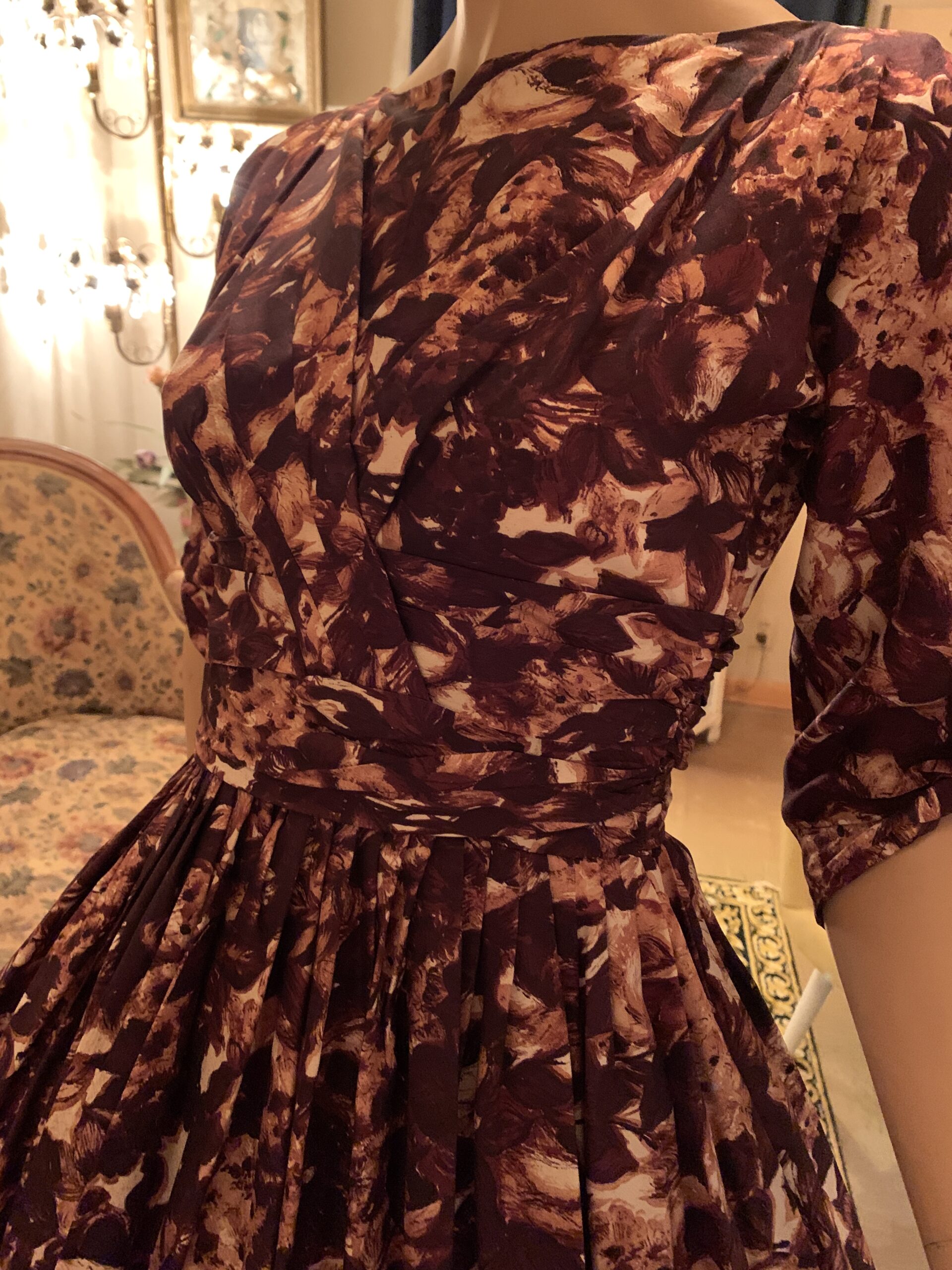 Close-up of the fitted bodice and ruched waist on a 1950s Carol Craig New York chocolate brown abstract floral dress.