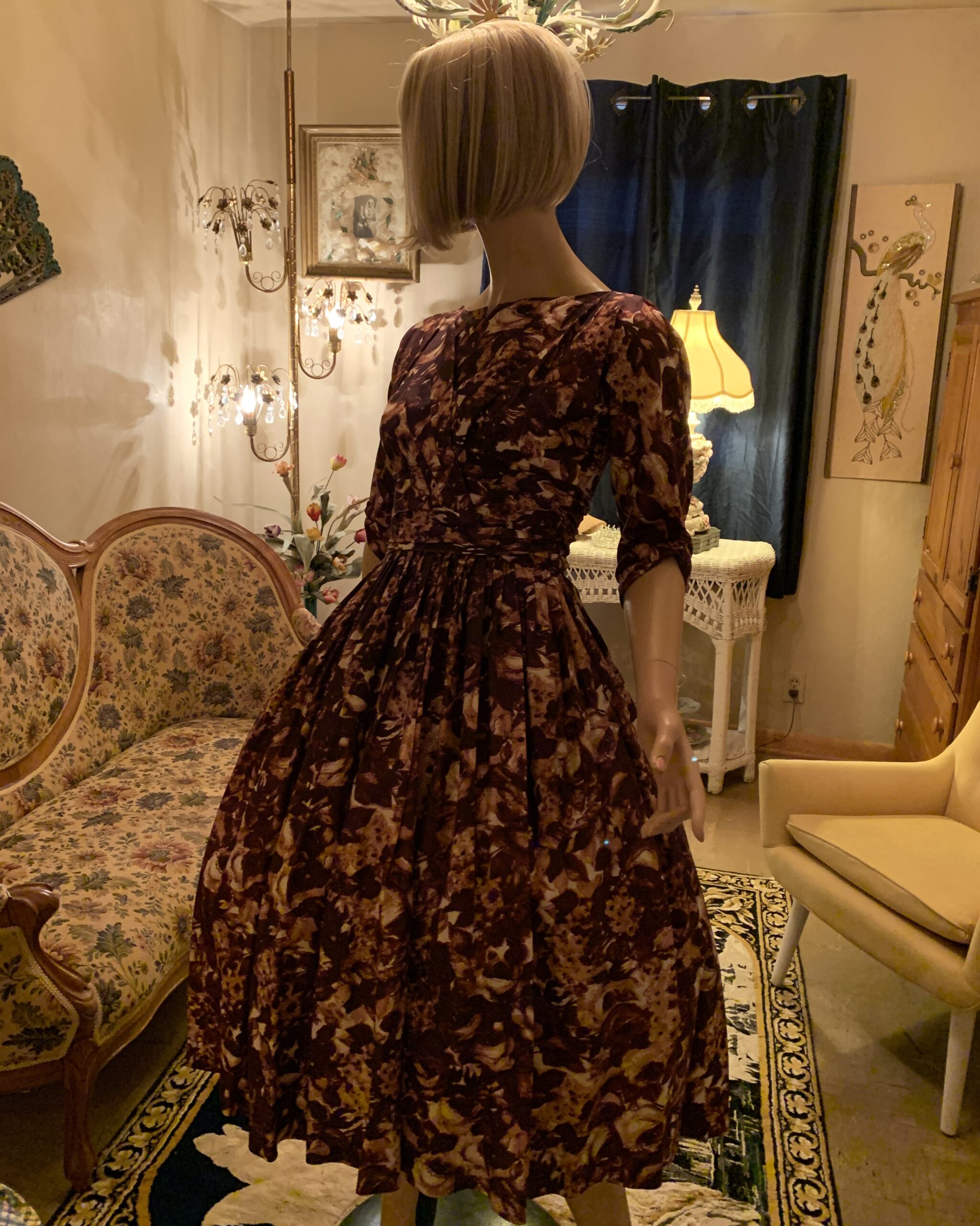 Three-quarter view of a 1950s Carol Craig New York chocolate brown abstract floral dress showcasing its elegant silhouette and full skirt.