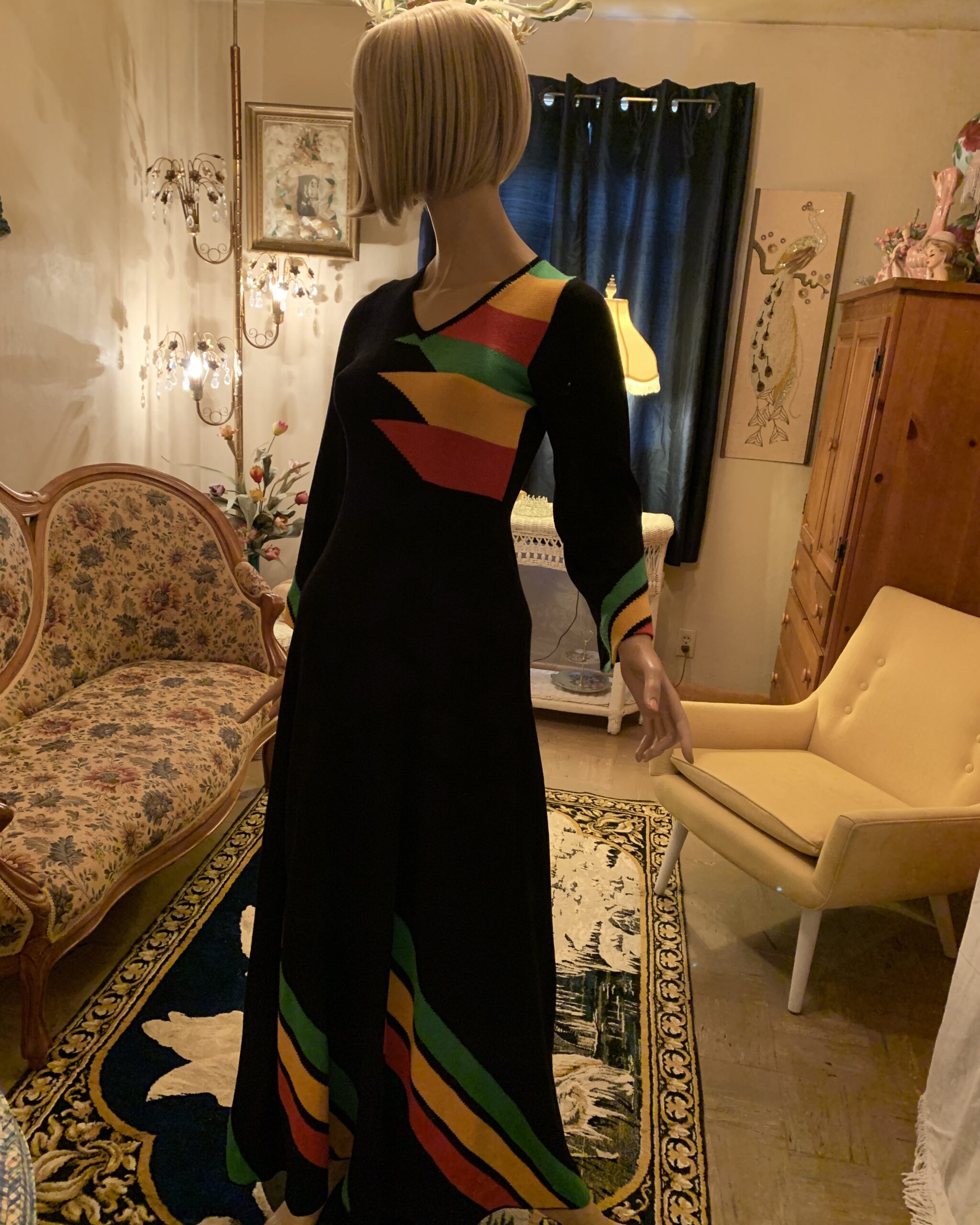 Three-quarter view of black vintage colorblock maxi dress with long sleeves, fitted silhouette and sweeping multicolor knit design.