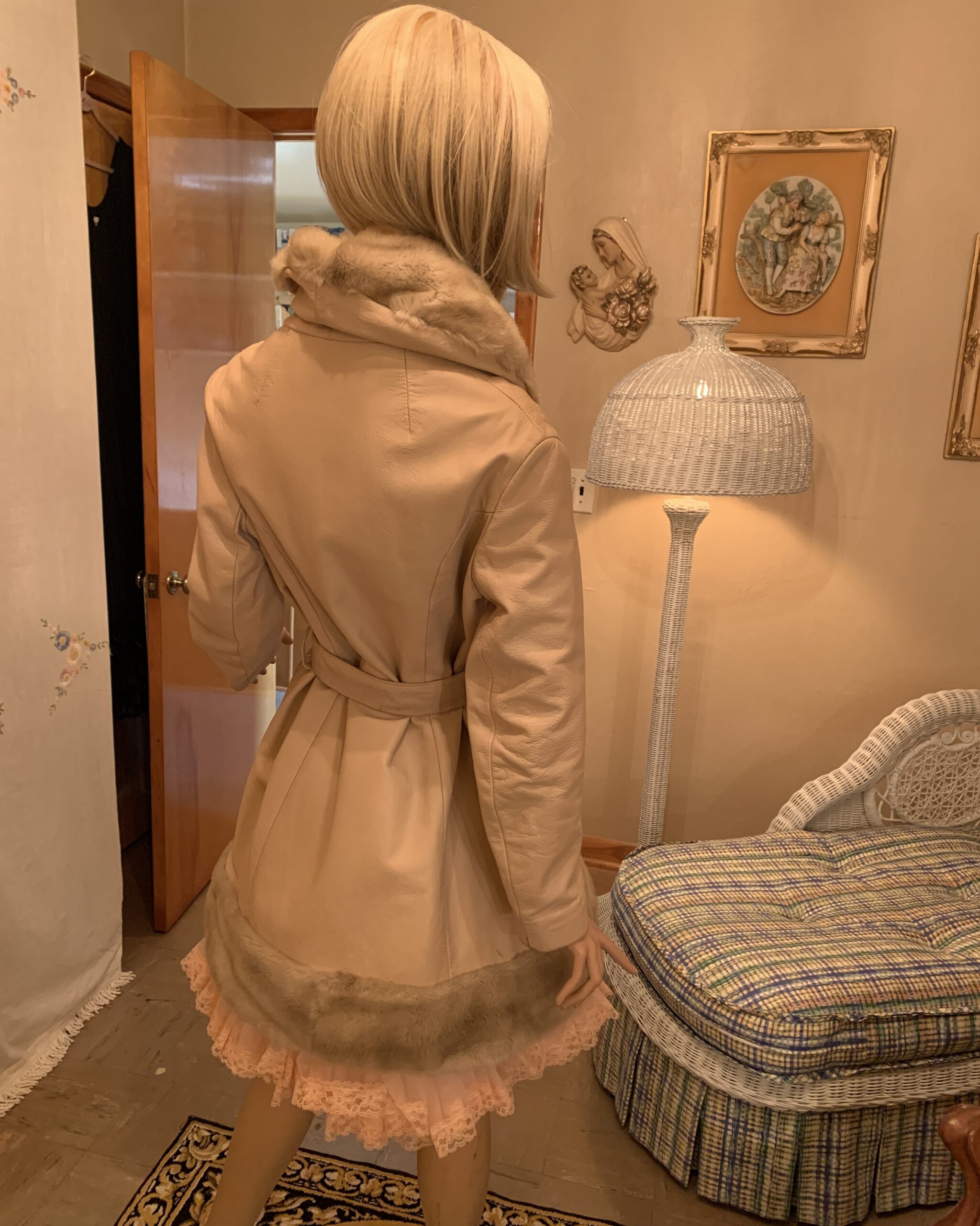 Back view of a vintage Lilli Ann London champagne leather coat with belted waist, faux fur hem, and tailored silhouette.