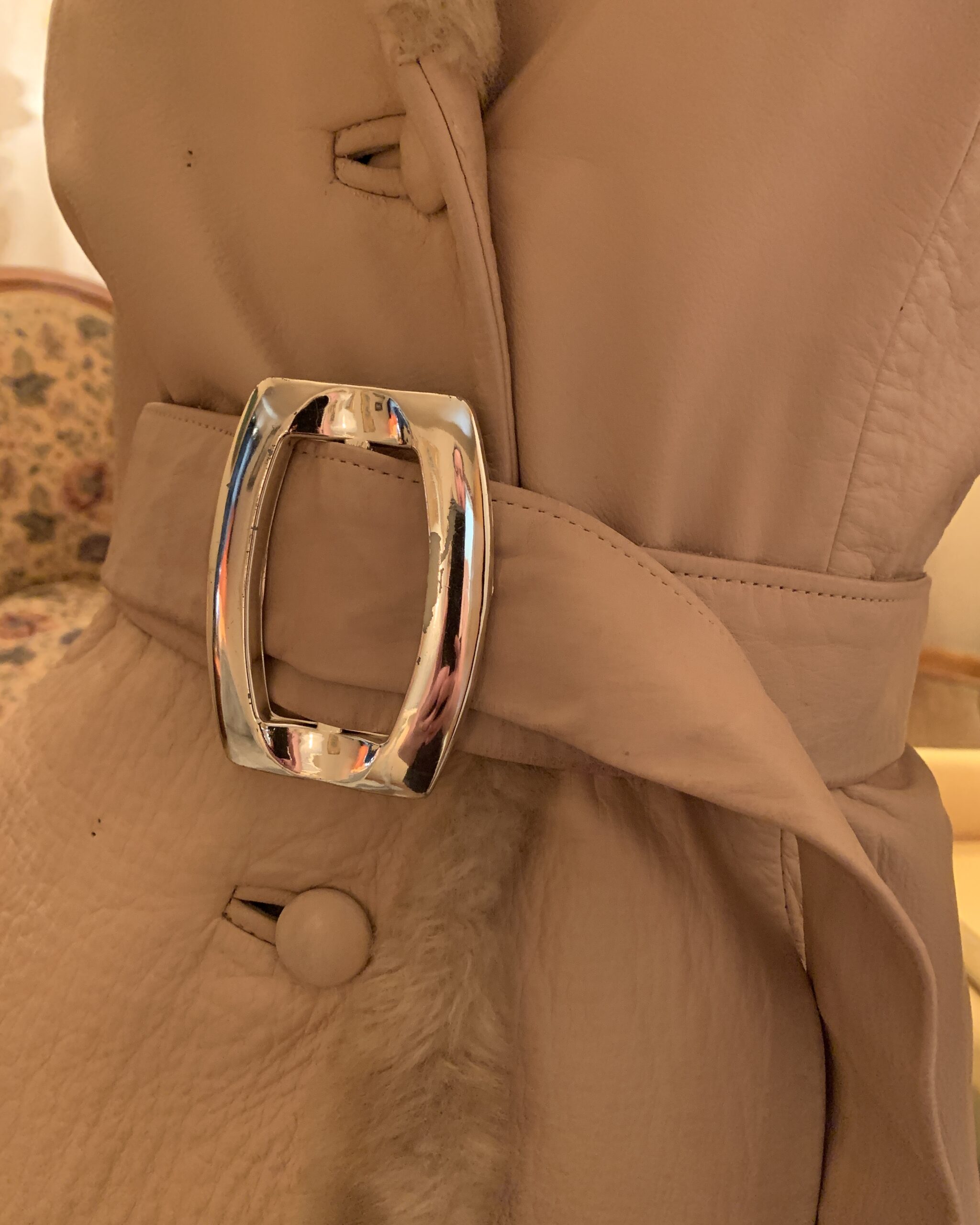 Original oversized chrome belt buckle on a vintage Lilli Ann London champagne leather coat.