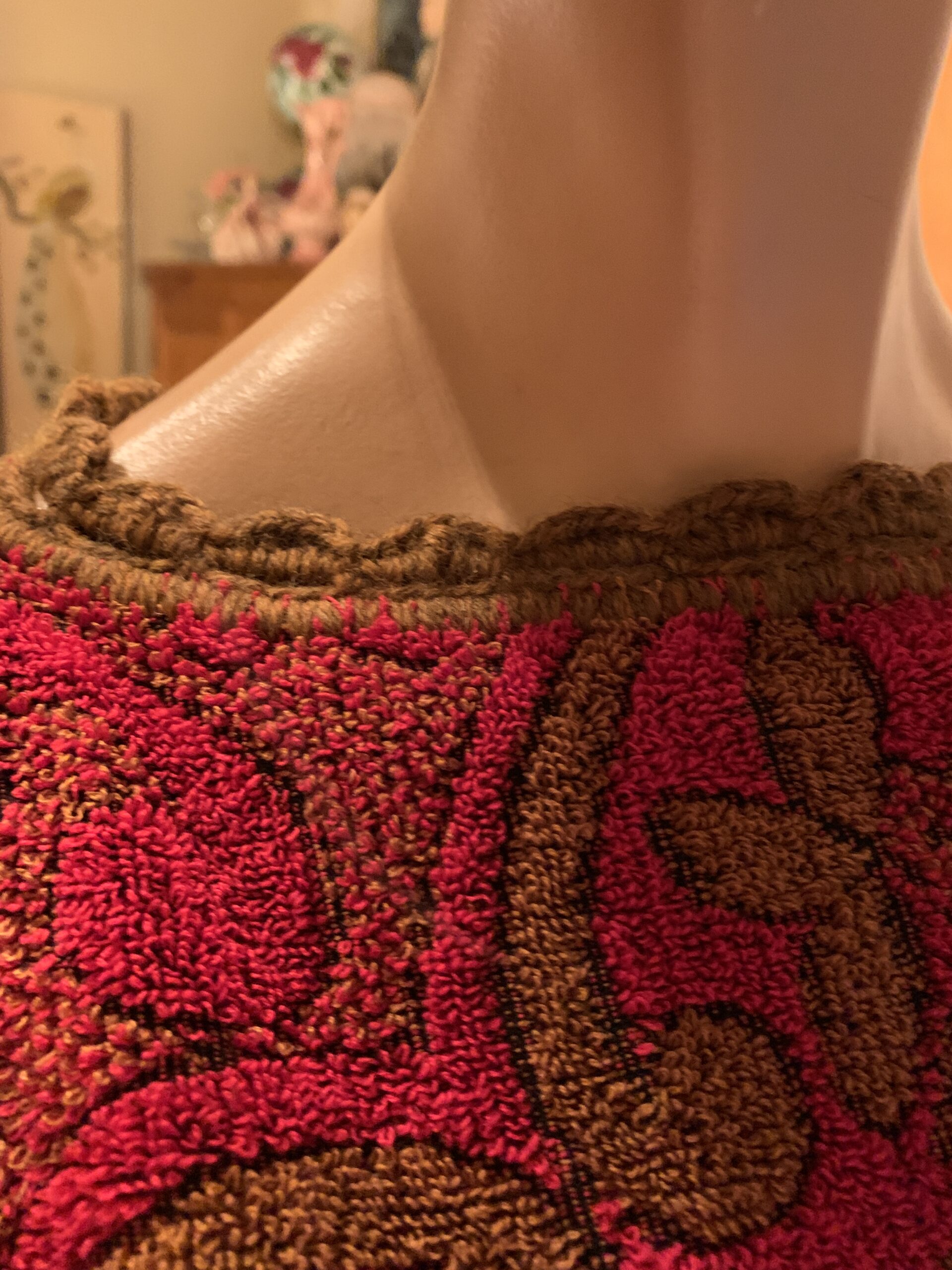 Close-up of vintage Cannon Cavalier towel dress neckline with textured brown trim and raised terry floral pattern.