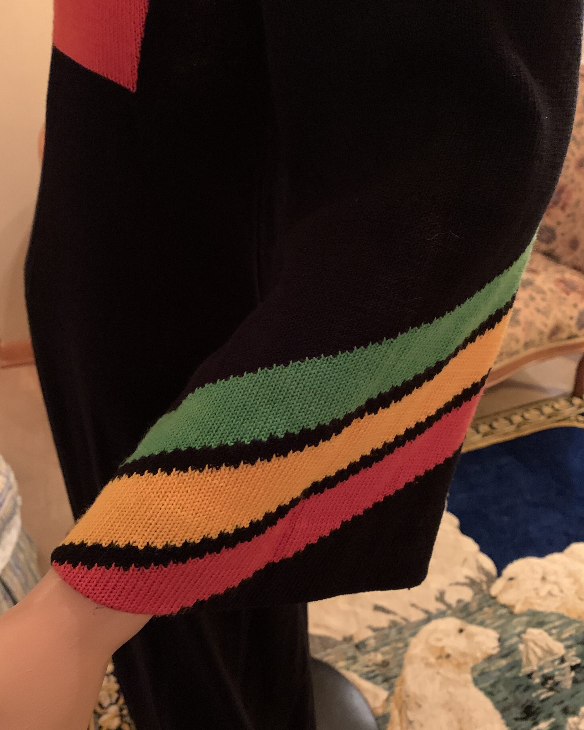 Close-up of flared bell sleeve on vintage mercerized cotton maxi dress with green, golden yellow and red knitted stripe detail.