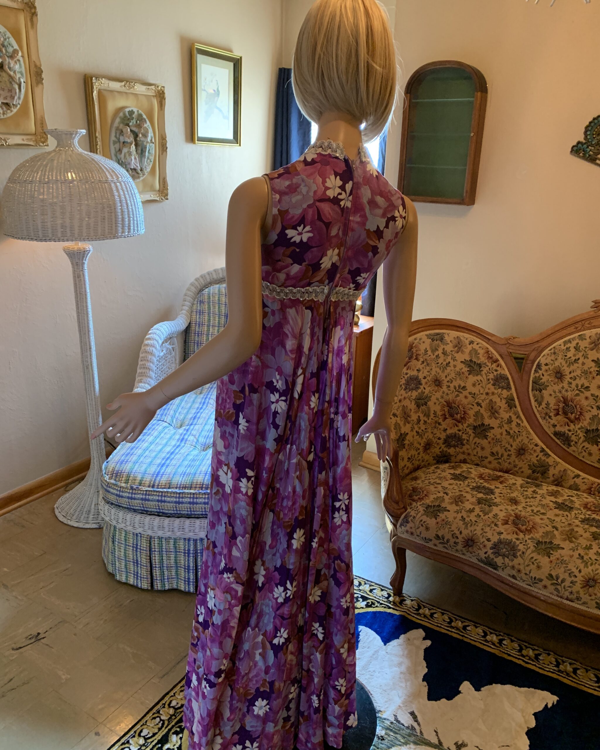 Back view of the purple floral Vogue Couturier jumpsuit showing the fitted bodice, empire seam, and rear zipper.