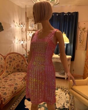 Side view of 1960s pink iridescent sequin cocktail dress on mannequin