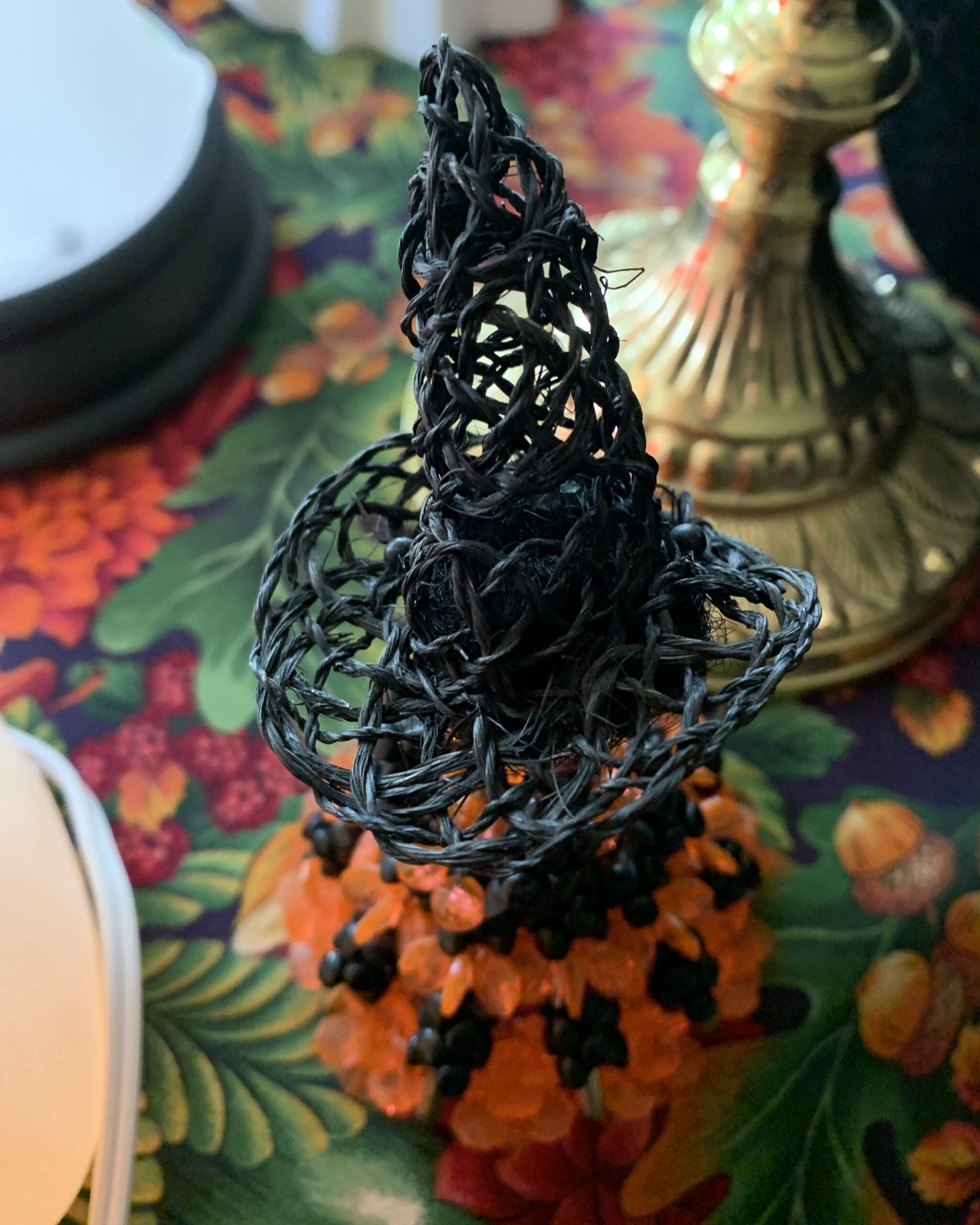 Detail of the doll’s handwoven black witch hat with oversized crooked brim.