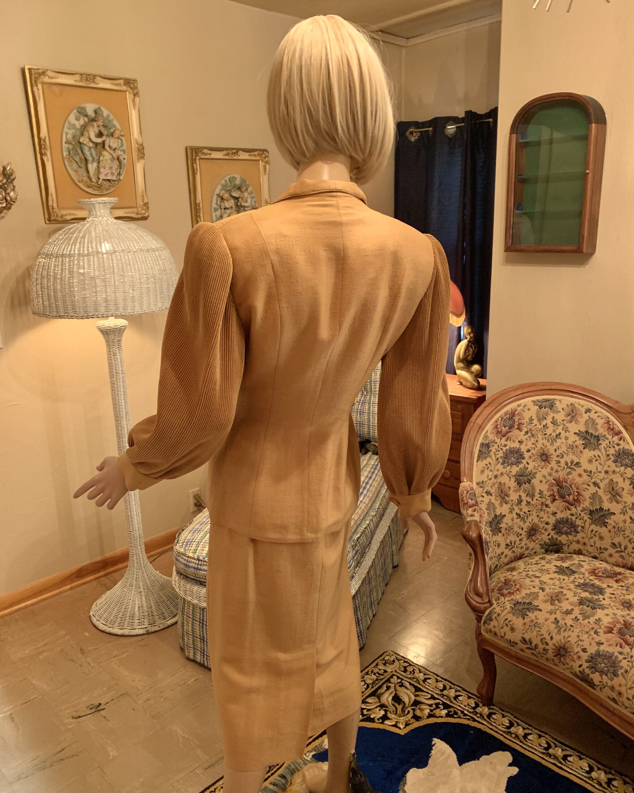 Back view of the Lilli Ann skirt suit showing the tailored jacket seams, full pleated sleeves, and matching straight skirt.