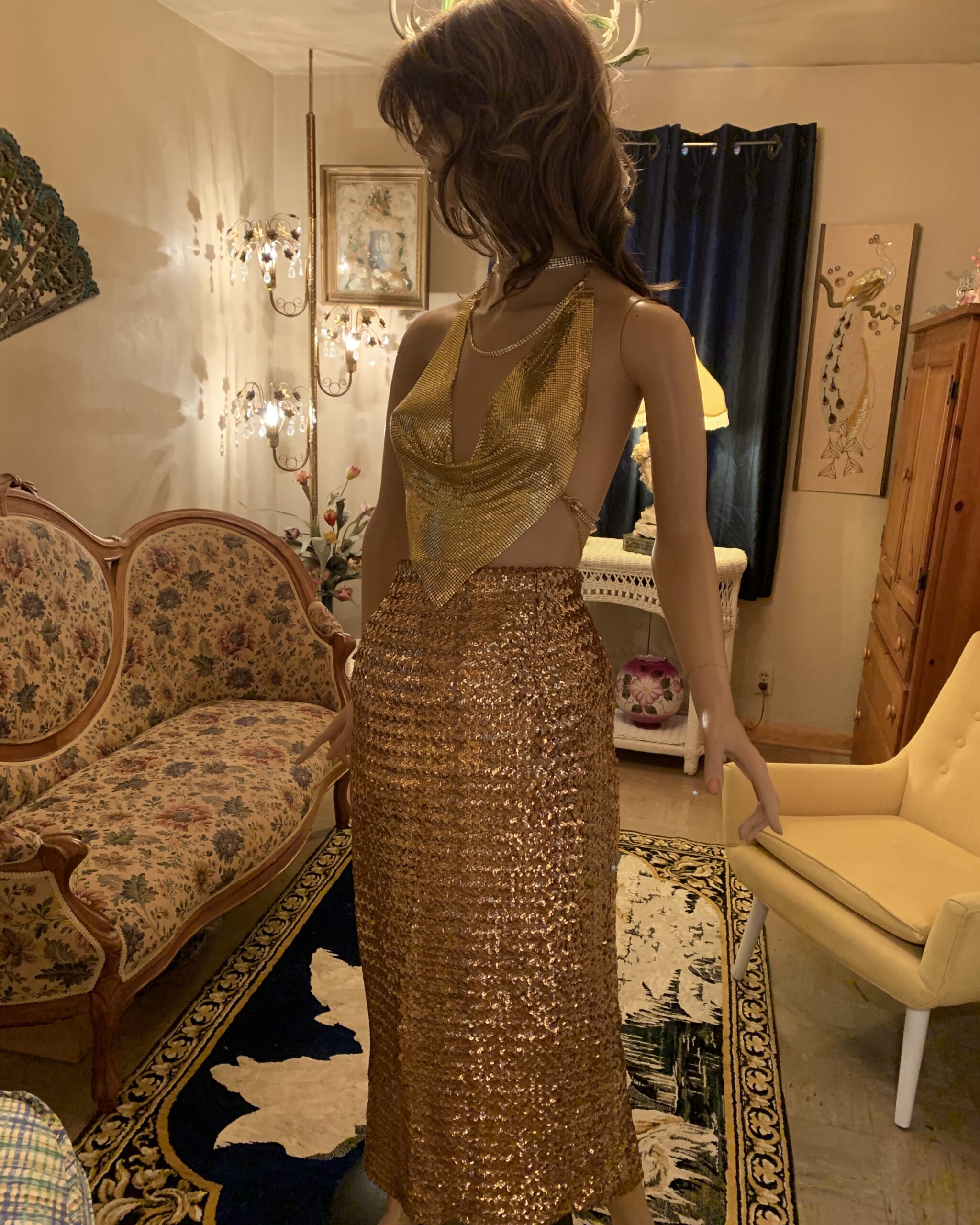 Vintage gold metal mesh top styled with a gold sequined skirt on a mannequin in the salon.